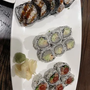 a plate of sushi and a bowl of sauce