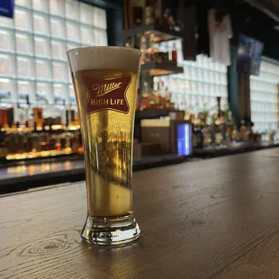 a glass of beer on a bar