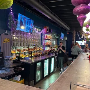 a bar with people standing at the bar