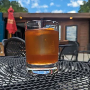 a glass of tea on a table outside