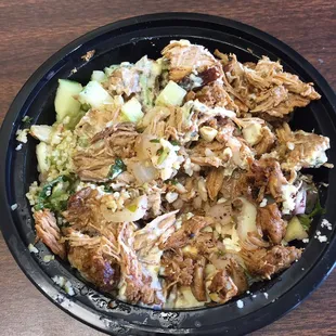 Pork bowl with cucumbers, onions, feta, tabouli, and tzatziki.