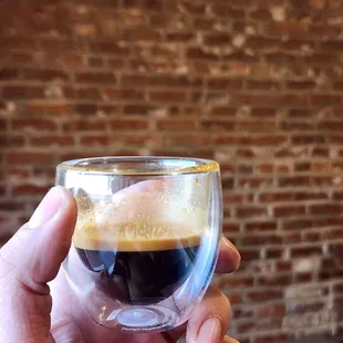 a hand holding a glass of coffee