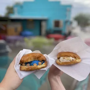 two hands holding two pastries