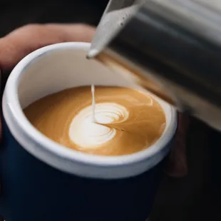 a person pouring milk into a cup