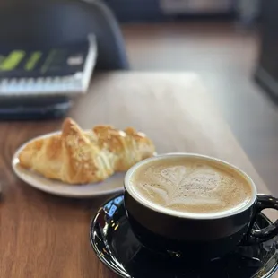 Sower&apos;s Cup with oat milk and an almond croissant.