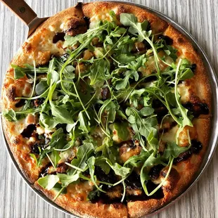 a pizza topped with greens