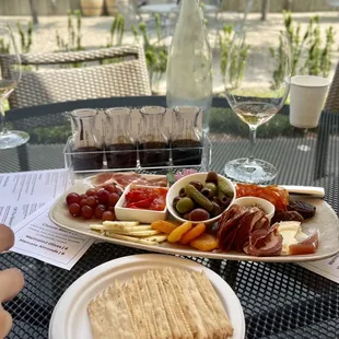 a plate of cheese, crackers, olives, and crackers