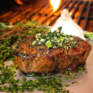 a steak on a plate with herbs