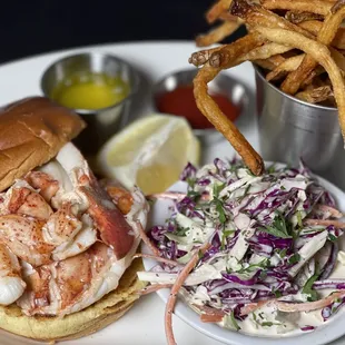  a lobster sandwich with coleslaw and fries