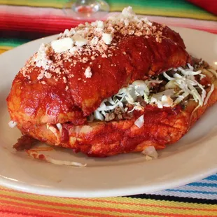 Panbazo, dipped in cascabel sauce, filled with picadillo