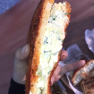 a person holding a sandwich in their hand