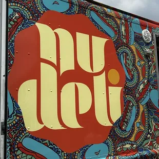 a colorful food truck with the word nu deli painted on it