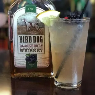 a drink and a bottle of bird dog blackberry whiskey