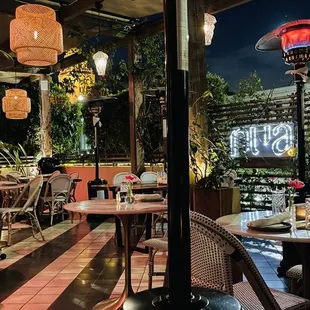 Patio is giving ambiance!!! Soft lights, wicker, fresh flowers, fireplaces and lots of greenery