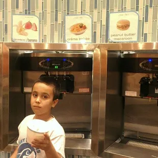 a young boy standing in front of a machine
