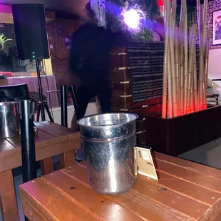 a metal bucket on a wooden table