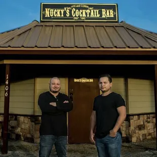 two men standing in front of a building