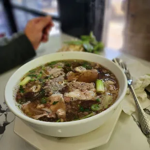 a bowl of soup with meat and vegetables