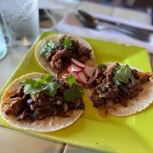 three tacos on a yellow plate