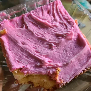 a piece of cake with pink frosting