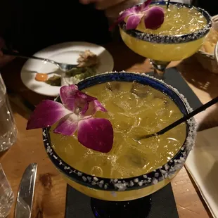 two margaritas with purple orchid garnish