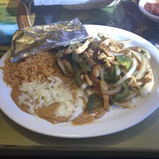 Fajitas the cook! This meal is absolutely delicious. It includes chicken, green peppers, tomatoes, onions, beans, rice, and flour tortillas.