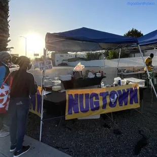 a group of people standing under a tent