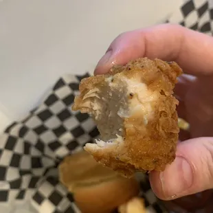 a hand holding a half eaten doughnut