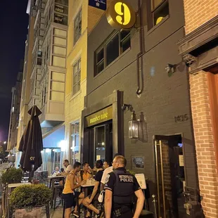 a group of people sitting outside of a restaurant