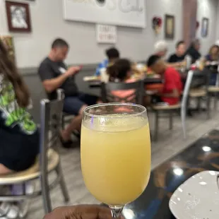 a person holding a glass of orange juice