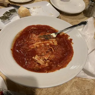 Lasagna fished to the surface of a bowl of sauce.