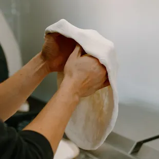 a person putting a towel on top of a pizza