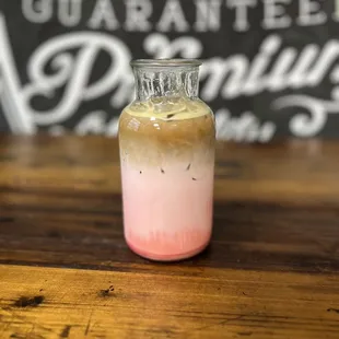 a jar of iced coffee on a wooden table