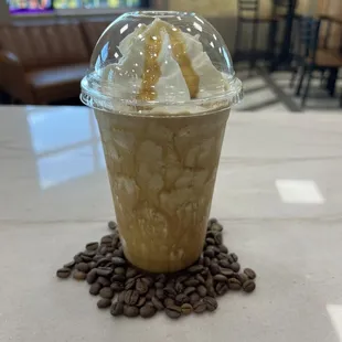 a cup of coffee with ice cream and coffee beans