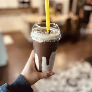 a hand holding a cup of iced coffee
