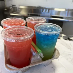 a tray of four drinks on a counter