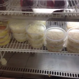 Top shelf: Red Velvet Cake. Bottom shelf: banana pudding, potato salad, and coleslaw.