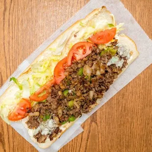 a hot dog with lettuce and tomatoes