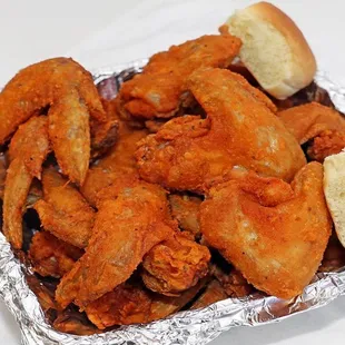 a tray of chicken wings and a roll