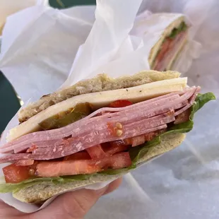 a hand holding a sandwich