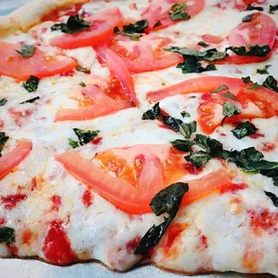 a pizza with tomatoes and spinach