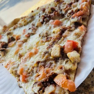 a slice of pizza on a paper plate