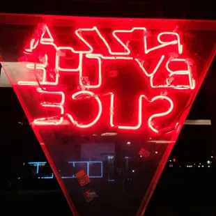 a neon pizza slice sign