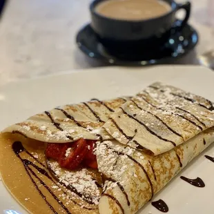 Strawberry, banana crepe with delightful latte.