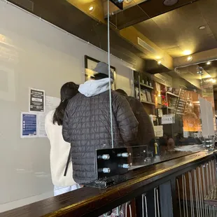 a woman standing at a counter in a restaurant