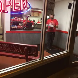 a man standing in the window of a restaurant