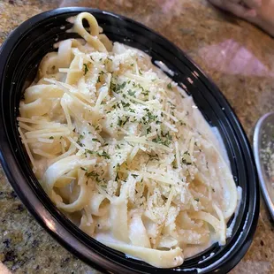 Fettuccine Alfredo served in a thin plastic take out bowl (dine in)