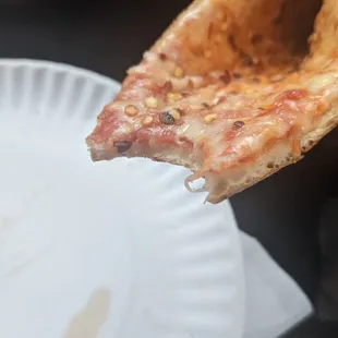 a piece of pizza being eaten