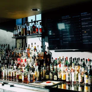 many bottles of alcohol lined up on the bar