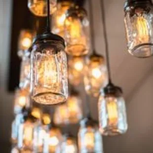 a cluster of mason jars hanging from a ceiling